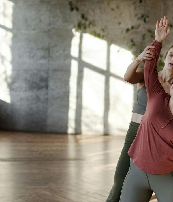 Person doing a stretching exercise in a bright, sunlit room.